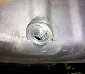 Stripped drain plug threads in an aluminum oil pan.