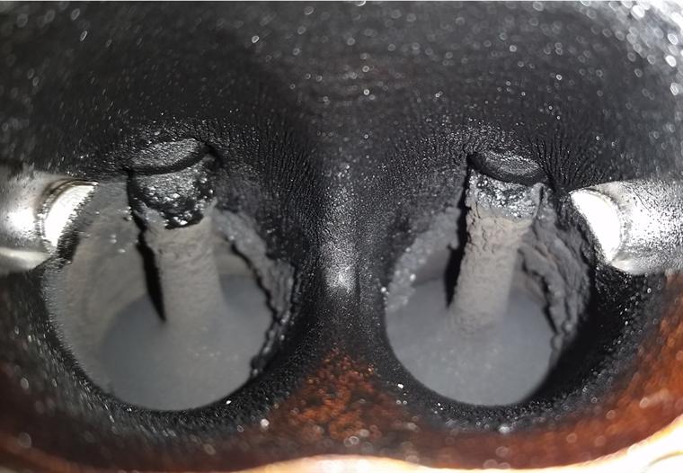 Intake ports before cleaning. That tar-like carbon is what the air has to get past.